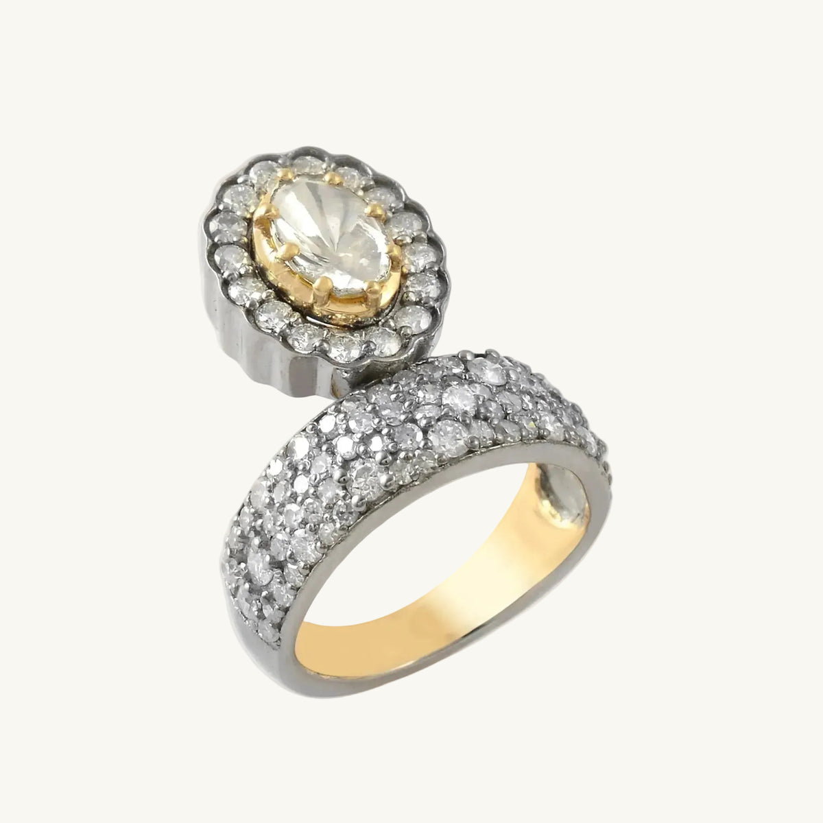 Gold and silver ring with a central gemstone on a white background