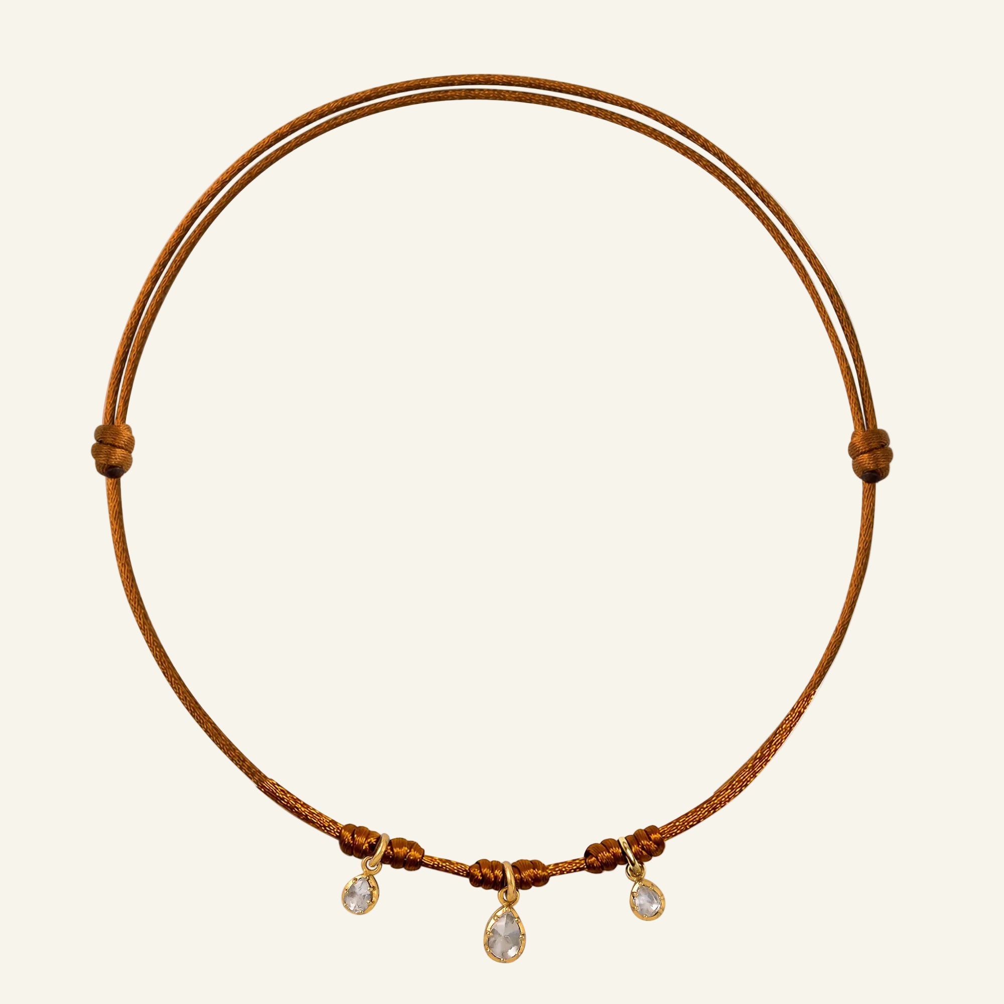 Brown cord necklace with small diamonds on a white background