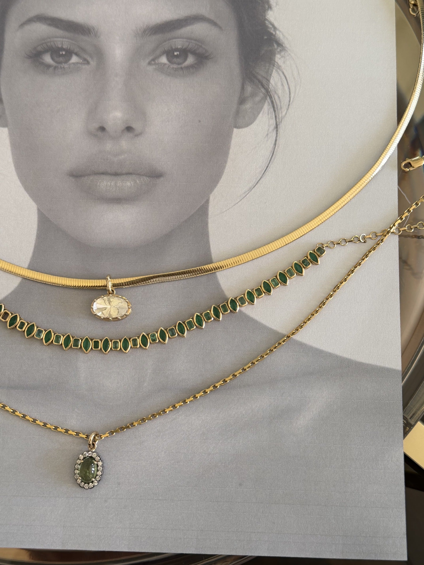DUNIYA necklaces arranged on an editorial photograph